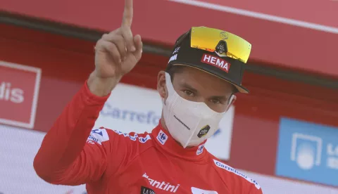 epa09420693 The overall leader, Slovenian Primo Roglic of Jumbo team, wearing the red maillot jersey, celebrates on the podium after the 6th stage of the Spanish Cycling Vuelta, a 158.3km-long race between Requena and Montana de Cullera, Spain, 19 August 2021. EPA/Manuel Bruque