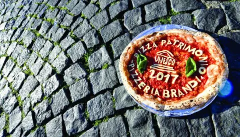 epa06373469 A pizza is placed on Plebiscito Square in Naples, Italy, 07 December 2017. Unesco announced the art of the Neapolitan 'Pizzaiuolo' (pizza making) has been put on its Intangible Cultural Heritage list. EPA/CIRO FUSCO ILLUSTRATION------ZADNJA, 3 stupca