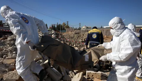 epa11780455 Members of the Syrian Civil Defense group, the White Helmets, carry a body bag after several bodies and human remains were discovered along a road leading to the airport in Damascus, Syria, 16 December 2024. According to the White Helmets, 17 bodies and 24 bags containing human bones were found dumped on the side of the road leading to Damascus International Airport, and an investigation was launched to determine the identities of the bodies and the circumstances of death. EPA/MOHAMMED AL RIFAI