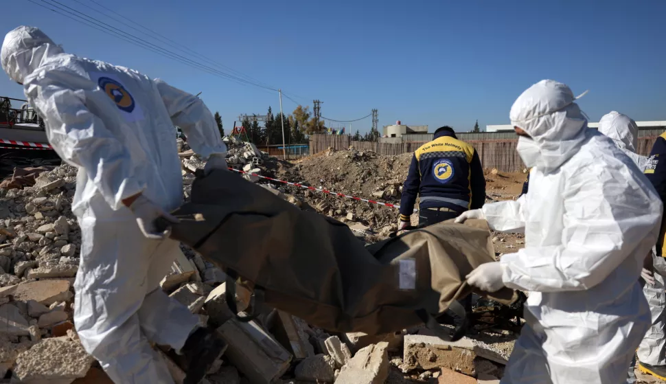 epa11780455 Members of the Syrian Civil Defense group, the White Helmets, carry a body bag after several bodies and human remains were discovered along a road leading to the airport in Damascus, Syria, 16 December 2024. According to the White Helmets, 17 bodies and 24 bags containing human bones were found dumped on the side of the road leading to Damascus International Airport, and an investigation was launched to determine the identities of the bodies and the circumstances of death. EPA/MOHAMMED AL RIFAI