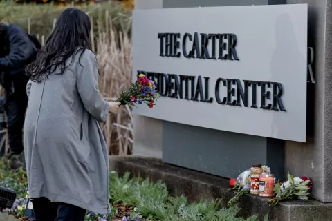 epa11798143 Mourner Esther Hyejin Chung arrives to leave flowers in reaction to the death of former US President Jimmy Carter at the Carter Presidential Center Atlanta, Georgia, USA, 29 December 2024. Carter died on 29 December 2024 at his home in Plains, Georgia, The Carter Center confirmed. Carter was the 39th US President and a winner of the Nobel Peace Prize. He was also the longest-lived president in US history. EPA/ERIK S. LESSER