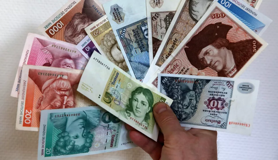 Deutschmarks are held up at a branch of the German Central Bank in Rostock, Germany, 23 December 2013. Every year in Germany, millions worth of Deutschmarks are still being exchanged for euros. Photo: Bernd Wuestneck/DPA/PIXSELL