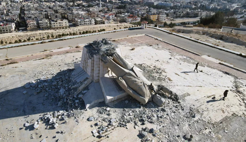 epaselect epa11824098 An aerial picture taken by drone shows a general view of the statue of former Syrian President Hafez al-Assad lying on the ground on one of the hills of the town of Deir Atiyah, Qalamoun, Syria 14 January 2025, after the Syrian opposition toppled it with the fall of Bashar al-Assad's regime in early December 2024. EPA/MOHAMMED AL RIFAI