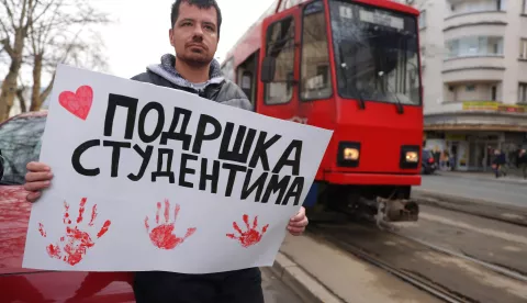 epa11860289 A protester holds a banner reading 'Support for students' during a fifteen-minute silence to honor the victims of the Novi Sad train station accident, outside the Faculty of Law in Belgrade, Serbia, 29 January 2025. University students staged a protest, demanding accountability after fifteen people lost their lives in the collapse of the Novi Sad Railway Station canopy on 01 November 2024. The station building, which had been renovated and reopened on 05 July 2024, was undergoing further renovations shortly before the collapse. EPA/ANDREJ CUKIC