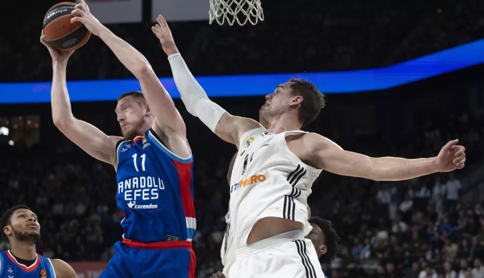 epa11875134 Real Madrid's Mario Hezonja (R) in action against Anadolu Efes' Roland Smits (L) during the Euroleague basketball match between Anadolu Efes and Real Madrid in Istanbul, Turkey, 04 February 2025. EPA/TOLGA BOZOGLU
