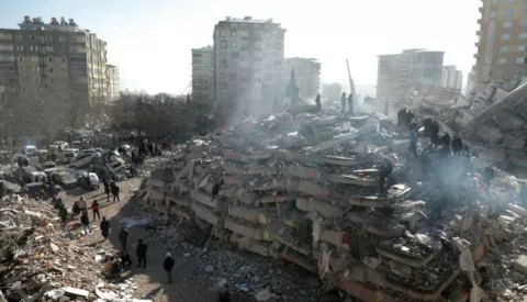 epa10455117 People search the rubble of a collapsed building in the city of Kahramanmaras, southeastern Turkey, 08 February 2023. More than 11,000 people have died and thousands more are injured after two major earthquakes struck southern Turkey and northern Syria on 06 February. Authorities fear the death toll will keep climbing as rescuers look for survivors across the region. EPA/ABIR SULTAN