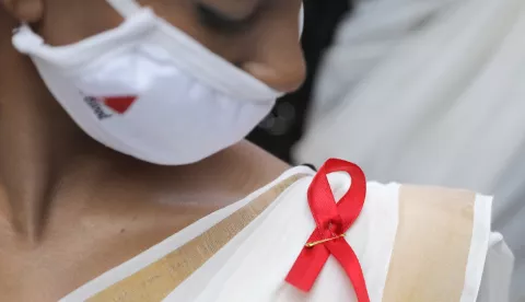 epa08854188 A voulnteer wears a red AIDS ribbon badge during an awareness rally on World AIDS Day, organized by the Durbar Mahila Samanwaya Committee in the Sonagachi red light district, in Kolkata, India 01 December 2020. World AIDS Day is annually observed on 01 December with calls from international health and advocacy organizations for the public to get involved in programs for awareness, prevention and treatment of Human immunodeficiency virus infection and acquired immune deficiency syndrome (HIV/AIDS). EPA/PIYAL ADHIKARY