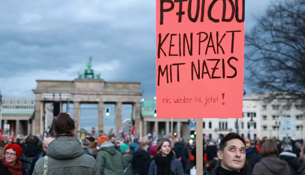 epa11852235 A participant holds a placard that reads 'Ugh, CDU (party). No pact with Nazis. Never again is now!' during a rally against the far right at the Brandenburg Gate in Berlin, Germany, 25 January 2025. In the wake of US President Donald Trump taking office and one month before the German federal elections, a civil society alliance is initiating the Sea of Lights in front of the Brandenburg Gate to protect democracy against right-wing extremism. EPA/CLEMENS BILAN