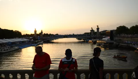 epa11507787 People look at the Seine river at the location of the Men's Triathlon course near Pont Alexandre III during the Paris 2024 Olympic Games in Paris, France, 30 July 2024. The Men's Triathlon event scheduled for 30 July has been postponed to 31 July 'due to water quality', the Olympics communications department confirmed. EPA/JOEL CARRETT AUSTRALIA AND NEW ZEALAND OUT