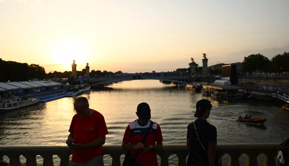 epa11507787 People look at the Seine river at the location of the Men's Triathlon course near Pont Alexandre III during the Paris 2024 Olympic Games in Paris, France, 30 July 2024. The Men's Triathlon event scheduled for 30 July has been postponed to 31 July 'due to water quality', the Olympics communications department confirmed. EPA/JOEL CARRETT AUSTRALIA AND NEW ZEALAND OUT