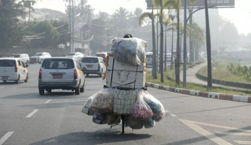 epa11903959 A man carries snacks on the back of a bicycle through a high level of air pollution in Yangon, Myanmar, 18 February 2025. EPA/NYEIN CHAN NAING