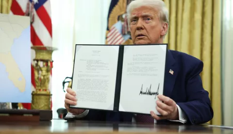 epa11893876 US President Donald Trump holds up a signed executive order in the Oval Office at the White House in Washington, DC, USA, 13 February 2025. EPA/FRANCIS CHUNG/POOL