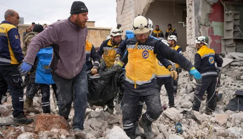 epa11909743 Members of the Syrian Civil Defense, known as the White Helmets, carry a dead body after an explosion of war remnants that a person was collecting and working with, in the town of Al-Nairab in the eastern countryside of Idlib, Syria, 20 February 2025. The Syrian Civil Defense said that at least four people were killed as a result of the explosion and a child was also injured, while the Civil Defense teams are searching for victims at the scene. EPA/AHMAD FALHALA