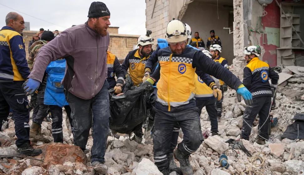 epa11909743 Members of the Syrian Civil Defense, known as the White Helmets, carry a dead body after an explosion of war remnants that a person was collecting and working with, in the town of Al-Nairab in the eastern countryside of Idlib, Syria, 20 February 2025. The Syrian Civil Defense said that at least four people were killed as a result of the explosion and a child was also injured, while the Civil Defense teams are searching for victims at the scene. EPA/AHMAD FALHALA