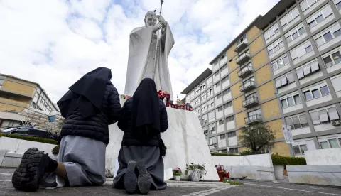 epa11910230 Two nuns pray under the statue of Pope John Paul II, at the Gemelli polyclinic, where Pope Francis is hospitalized in Rome, Italy, 20 February 2025. Pope Francis is continuing to do some work while he is being treated at Rome's Gemelli hospital for bronchitis and double pneumonia, Vatican sources said on Thursday. Pope Francis was hospitalized on 14 February due to a respiratory tract infection. EPA/MASSIMO PERCOSSI