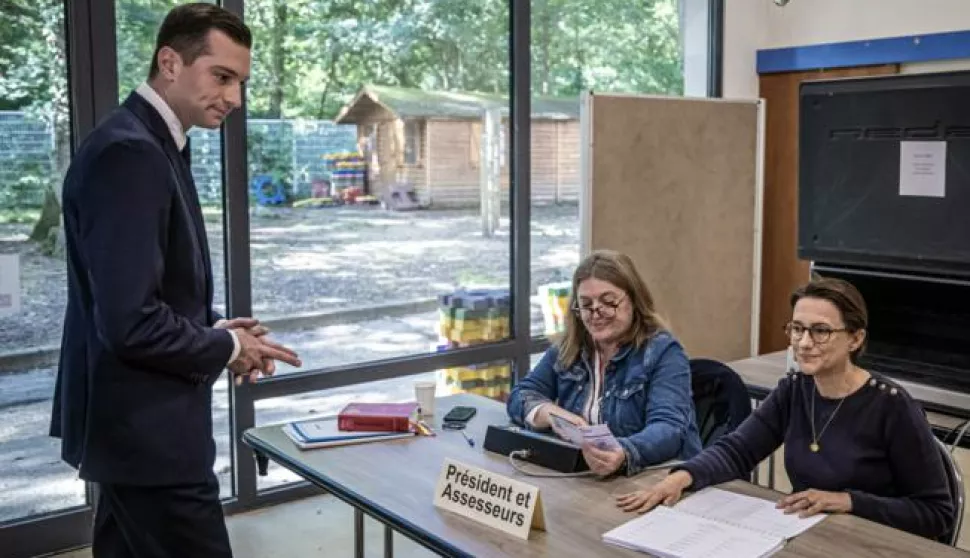 epa11446819 French far-right party National Rally (RN) President Jordan Bardella (L) prepares to cast his vote at an electronic polling station in the first round of the parliamentary elections, in Garches, near Paris, France, 30 June 2024. France on 30 June holds the first round of snap parliamentary elections called by President Emmanuel Macron, after dissolving the National Assembly on 09 June 2024. EPA/CHRISTOPHE PETIT TESSON