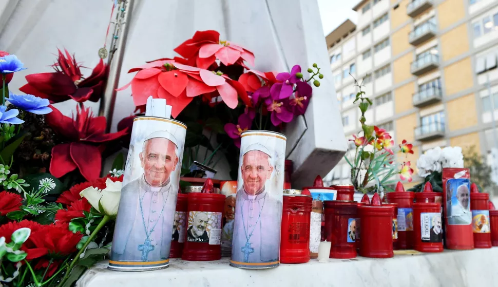 epa11912070 Flowers and candles lay at the foot of a statue of Pope St. John Paul II outside Gemelli University Hospital, where Pope Francis is hospitalized for bronchitis treatment, in Rome, Italy, 21 February 2025. Pope Francis was hospitalized on 14 February due to a respiratory tract infection. EPA/FABIO CIMAGLIA