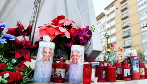 epa11912070 Flowers and candles lay at the foot of a statue of Pope St. John Paul II outside Gemelli University Hospital, where Pope Francis is hospitalized for bronchitis treatment, in Rome, Italy, 21 February 2025. Pope Francis was hospitalized on 14 February due to a respiratory tract infection. EPA/FABIO CIMAGLIA