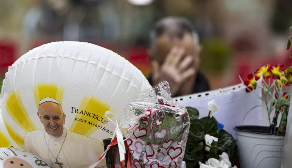 epaselect epa11923160 A man (back) prays outside the Agostino Gemelli hospital, where Pope Francis is currently hospitalized, in Rome, Italy, 25 February 2025. The pope was admitted to hospital on 14 February due to a respiratory tract infection. EPA/MASSIMO PERCOSSI
