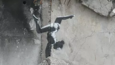 epa10303592 A mural depicting a gymnast and attributed to British street artist Banksy is pictured at a wall of a building that was destroyed during shelling in Borodyanka, Ukraine, 13 November 2022. A photo of the gymnast mural in Borodyanka was shared by Banksy on his social media channel on 11 November, while other works found in different locations in Ukraine and resembling Banksy's style have not been shared on the artist's channel yet. Russian troops entered Ukraine on 24 February 2022, starting a conflict that has provoked destruction and a humanitarian crisis. EPA/SERGEY DOLZHENKO