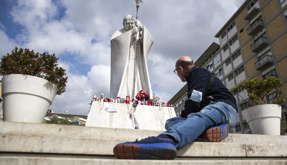 epa11930343 A faithful prays in front of the statue of Pope John Paul II outside the Gemelli University Hospital, where Pope Francis is hospitalized, in Rome, Italy, 28 February 2025. The pontiff was admitted to Rome's Gemelli Hospital on 14 February, due to a respiratory tract infection. EPA/ANGELO CARCONI