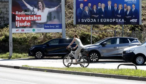 epa11392968 A woman rides a bicycle in front of campaign banners for Social Democratic Party (SDP) candidate Biljana Borzan (L) and the Croatian Democratic Union (HDZ) (R) featuring Croatian Prime Minister Andrej Plenkovic (C), as part of the European elections, in Zagreb, Croatia, 06 June 2024. The European Parliament elections take place across EU member states from 06 to 09 June 2024, with the European elections in Croatia to be held on 09 June. EPA/ANTONIO BAT