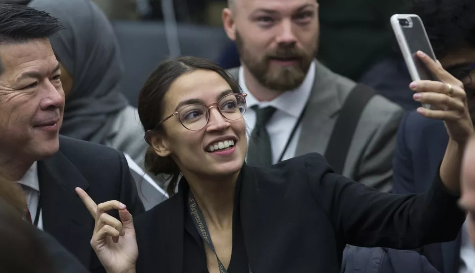 epa07199952 Democratic Representative-elect Alexandria Ocasio-Cortez (C) uses a cell phone while attending the US House Representative-elect office lottery in Washington, DC, USA, 30 November 2018. Incoming members of the 116th Congress, which convenes on 03 January 2019, participated in a lottery to determine their office space. EPA/MICHAEL REYNOLDS