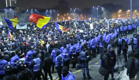 epa05765502 People wave flags and shout anti-government slogans during a protest rally in front of government headquarters in Bucharest, Romania, 01 February 2017. Up to 100,000 people gathered in front of government building and block the city traffic to protest against a government bill, that passed trough government session late 31 January, as a government ordinance to pardon those sentenced to jail terms shorter than five years, in the light that many Romanian parliament and administration members are having issues with justice. Other tenth of thousand people, estimated by national TV stations, participate in similar protests in big cities around the country this evening. Protest turned viloent after soccer fans entered the government plaza and charged the riot police with flares and stones. EPA/ROBERT GHEMENT
