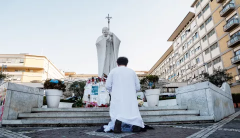 epa11943739 A person prays near the statue of John Paul II outside Agostino Gemelli Hospital where Pope Francis continues his treatments for bilateral pneumonia, in Rome, Italy, 06 March 2025. The pope was admitted to hospital on 14 February due to a respiratory tract infection. EPA/GIUSEPPE LAMI