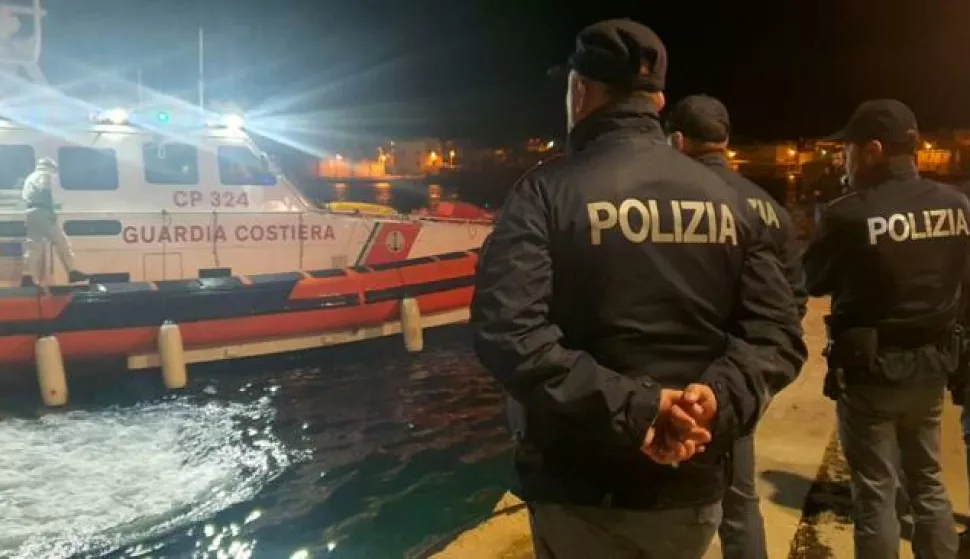 epa10445200 Police officers on the quay of the port wait for the boat containing the bodies of 8 migrants in Lampedusa, Sicily, Italy, 03 February 2023. The soldiers of a Coast Guard patrol boat rescued the boat, with dozens of North Africans on board and also the bodies. EPA/Concetta Rizzo