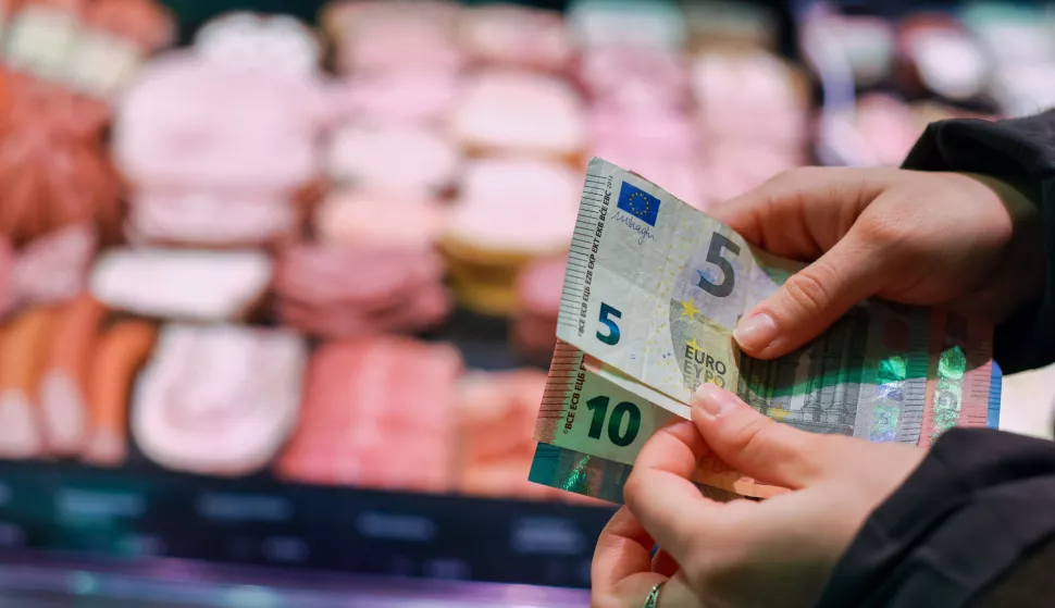 SYMBOL - 12 March 2025, Saxony, Leipzig: A woman stands in a butcher's shop with banknotes in her hand. The Federal Statistical Office announces the inflation rate for February 2025 in mid-March. Photo: Jan Woitas/dpa Photo: Jan Woitas/DPA