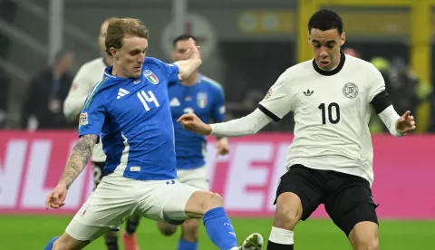 epa11976820 Germany's midfielder Jamal Musiala (R) and Italy's midfielder Nicolo Rovella struggle for the ball during the UEFA Nations League quarterfinals first leg soccer match between Italy and Germany at the Giuseppe Meazza Stadium in Milan, Italy, 20 March 2025. EPA/Daniel Dal Zennaro