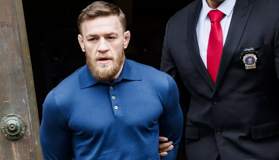epa06911752 (FILE) - Mixed martial arts (MMA) fighter Conor McGregor is escorted from a New York City police precinct after he turned himself and was arrested and charged with three counts of assault and one count of criminal mischief in Brooklyn, New York, USA, 06 April 2018 (reissued 26 July 2018). McGregor on 26 July 2018 accepted a plea deal and pleaded guilty to single violation of disorderly conduct. McGregor will serve five days of community woork following an incident at a media event at the Barclays Center where McGregor allegedly attacked a bus filled with other fighters and staff members. EPA/JUSTIN LANE *** Local Caption *** 54245418