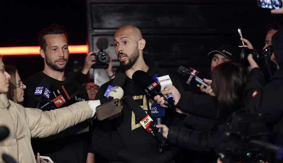 epa11980115 Former professional kickboxer and social media influencer Andrew Tate (C), accompanied by his brother Tristan (L), speaks with TV reporters after returning from a trip in the United States, in front of their property, in Bucharest, Romania, early 22 March 2025. After spending weeks in the USA, Tate brothers returned to Romania, where they face legal charges. Andrew Tate and his brother Tristan were arrested on 29 December 2022 as a result of the DIICOT (Directorate for Investigating Organized Crime and Terrorism) inquiry on charges of human trafficking and intention to form an organized crime group. Romanian police allege that the two brothers and their associates coerced victims for creating a paid pornography service for social media platforms. The trial itself has not started yet, as the appeal court judges sent the case back to DIICOT prosecutors by a decision made at the end of 2024. EPA/Robert Ghement