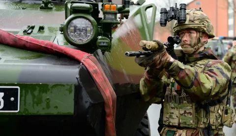 04 December 2024, Lower Saxony, Bergen: A soldier from Ireland stands with his weapon next to a vehicle during the MILEX24 military exercise. From November 25 to December 10, 2024, the EU is conducting a combat exercise with 1700 soldiers from 15 member states at the Bergen military training area. Photo: Philipp Schulze/dpa Photo: Philipp Schulze/DPA