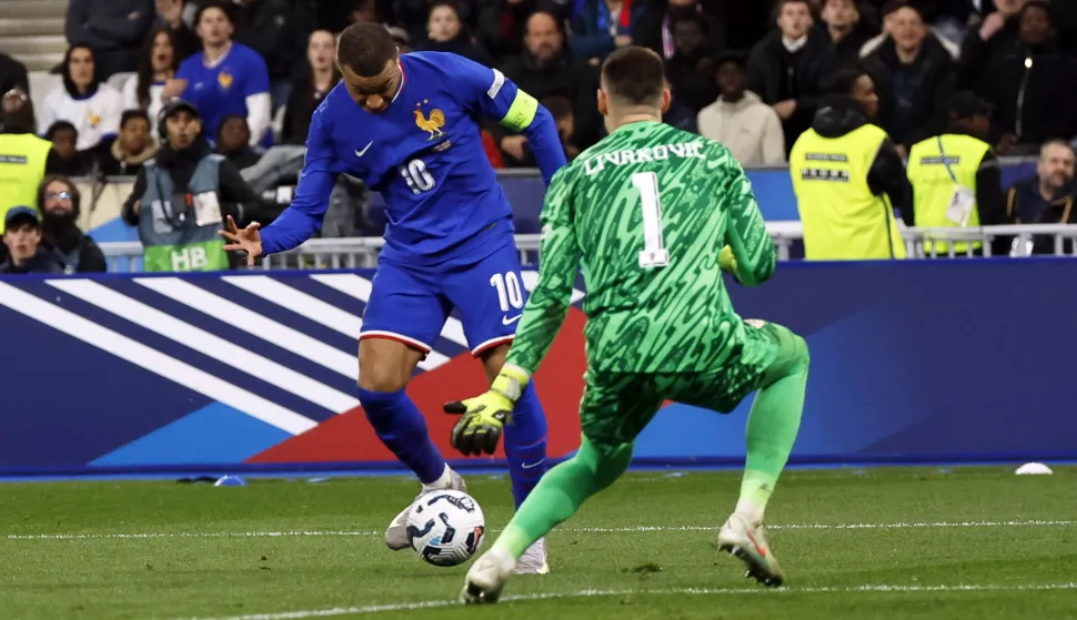 epa11984505 France's Kylian Mbappe (L) in action against Croatia's goalkeeper Dominik Livakovic (R) during the UEFA Nations League quarterfinal, 2nd leg match between France and Croatia at the Stade de France stadium in Saint Denis, France, 23 March 2025. EPA/MOHAMMED BADRA