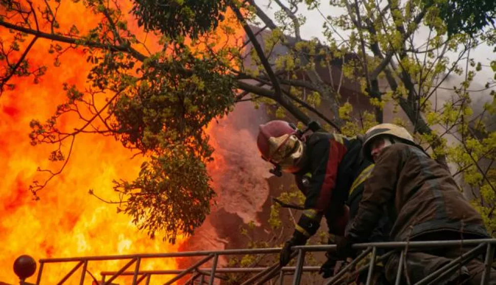 Harkiv, Ukrajina, 17.04.2022. - Vatrogasci gase poЕѕar na jednoj od ulica u Harkivu. Od posljedica ruske raketne paljbe u centru Harkiva pet je osoba poginulo, a 13 ozlijeД'eno. Vatrogasci su ugasili preko petnaest poЕѕara. foto (aldg) PAP/Mykola Kalyeniak