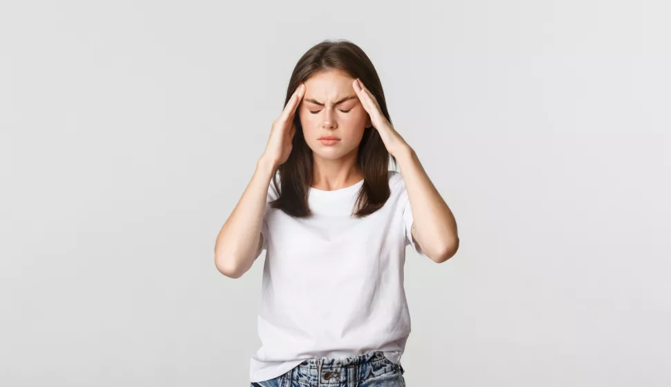 Portrait of dizzy or sick woman touching head and grimacing from pain, having headache, suffering migraine.migrena glavobolja