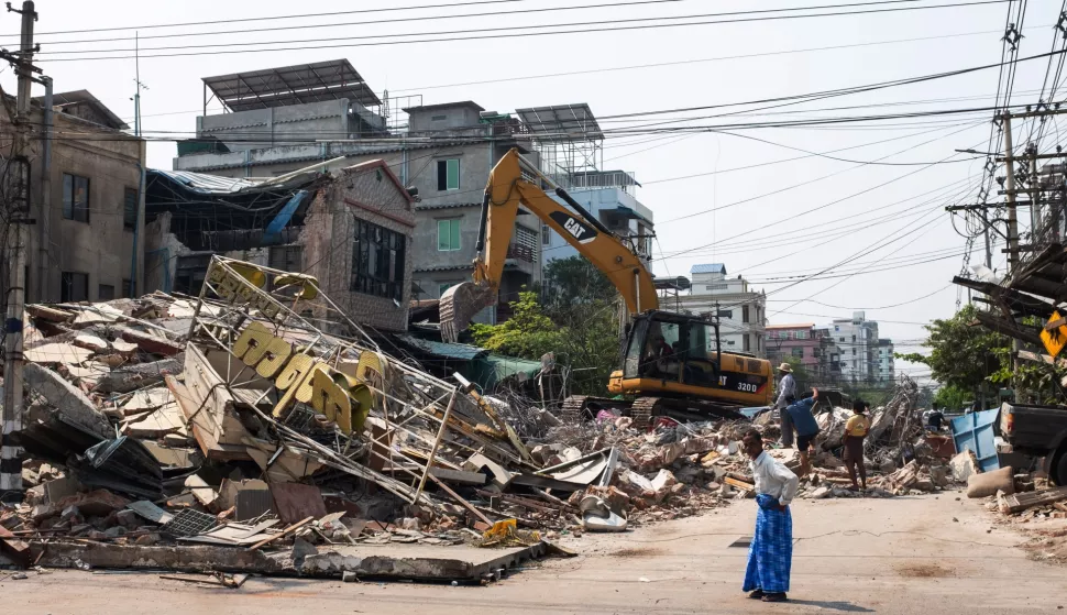 epa12001392 People look at a collapsed building following an earthquake in Mandalay, Myanmar, 31 March 2025. More than 1,700 people have been killed and thousands injured after a 7.7-magnitude earthquake struck the country on 28 March, according to the Myanmar government. EPA/STRINGER