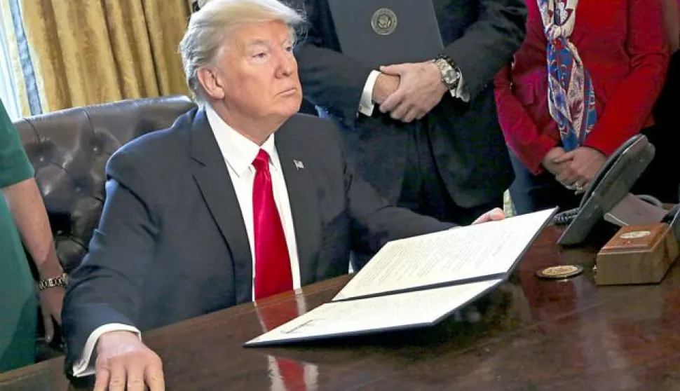 epa05769557 US President Donald J. Trump poses after signing an executive order in the Oval Office of the White House, in Washington, DC, USA, 03 February 2017. Trump signed several executive orders including an order to review the Dodd-Frank Wall Street to roll back financial regulations of the Obama era. EPA/Aude Guerrucci/POOL