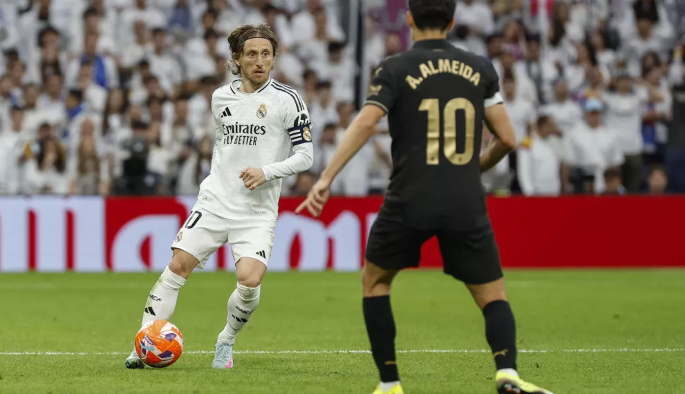 epa12011523 Real Madrid's Luka Modric (L) controls the ball before Valencia CF's Andre Almeida during the Spanish LaLiga match between Real Madrid and Valencia C.F. at Santiago Bernabeu stadium in Madrid, Spain, 05 April 2025. EPA/Chema Moya