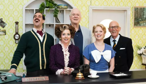 John Cleese (centre) with the cast of 'Fawlty Towers: The Play', (left to right) Danny Bayne as Basil Fawlty, Mia Austen as Sybil Fawlty, Joanne Clifton as Polly and Paul Nicholas as The Major, pictured at Jet Studios, west London. Picture date: Monday April 14, 2025. Photo: James Manning/PRESS ASSOCIATION