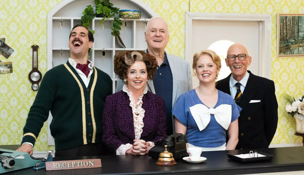 John Cleese (centre) with the cast of 'Fawlty Towers: The Play', (left to right) Danny Bayne as Basil Fawlty, Mia Austen as Sybil Fawlty, Joanne Clifton as Polly and Paul Nicholas as The Major, pictured at Jet Studios, west London. Picture date: Monday April 14, 2025. Photo: James Manning/PRESS ASSOCIATION