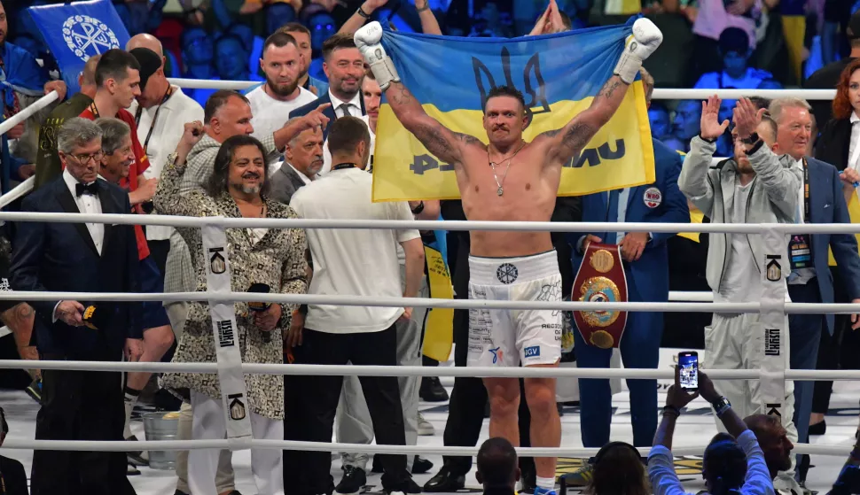 epa10822574 Oleksandr Usyk (C) of Ukraine celebrates his victory over Daniel Dubois of Great Britain after their heavyweight world title fight of four boxing federations; WBO, IBF, WBA, and IBO in Wroclaw, Poland, 26 August 2023. EPA/Sebastian Borowski POLAND OUT