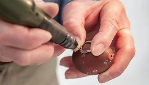 epa12036808 Craftsman Gyula Laszlo decorates an Easter egg with a tiny horseshoe by carefully nailing it to the shell in the Mives Eggs Museum in Zengovarkony, Hungary, 17 April 2025. EPA/Tamas Kacsur HUNGARY OUT
