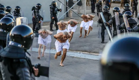 epa10488943 A handout photo made available by the government of El Salvador shows riot police watching the transfer of inmates to the Terrorism Confinement Center (CECOT) in Tecoluca, El Salvador, 24 February 2023. The Government of El Salvador moved some 2,000 suspected gang members to the new prison that has a capacity for some 40,000 inamtes. EPA/Government of El Salvador HANDOUT HANDOUT EDITORIAL USE ONLY/NO SALES