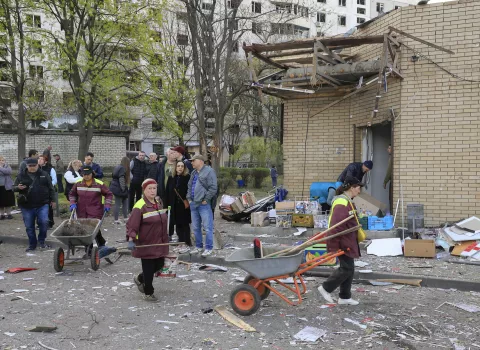epa12038475 People stand at the site of a rocket attack near a high-rise building in a residential area in Kharkiv, Ukraine, 18 April 2025, amid the ongoing Russian invasion. At least one person died, and more than 80 others were injured, including six children, according to the State Emergency Service. EPA/SERGEY KOZLOV