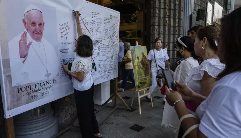 epa12050591 Catholic parishoners write on a message board for the late Pope Francis outside the Saint Peter Parish church in Quezon City, Metro Manila, Philippines 24 April 2025. Philippine President Ferdinand Marcos Jr. has declared a period of mourning in the country until Pope Francis' burial on 26 April. EPA/ROLEX DELA PENA