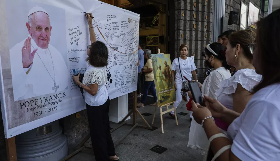 epa12050591 Catholic parishoners write on a message board for the late Pope Francis outside the Saint Peter Parish church in Quezon City, Metro Manila, Philippines 24 April 2025. Philippine President Ferdinand Marcos Jr. has declared a period of mourning in the country until Pope Francis' burial on 26 April. EPA/ROLEX DELA PENA