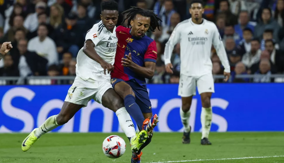 epa11685938 Real Madrid's Vinicius Jr. (L) in action against Jules Kounde of FC Barcelona during the Spanish LaLiga soccer match between Real Madrid and FC Barcelona, in Madrid, Spain, 26 October 2024. EPA/KIKO HUESCA
